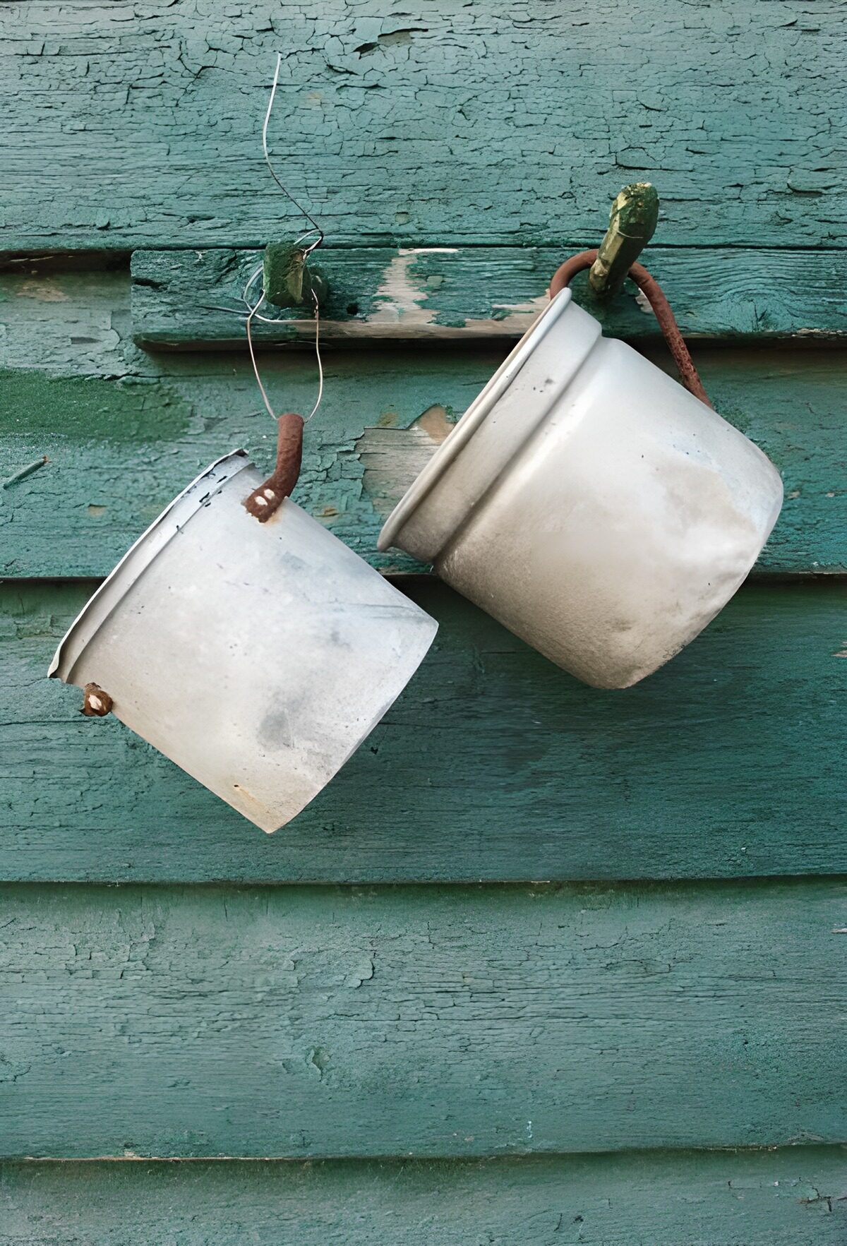 WCUK73568: Two pots hanging on a green wall