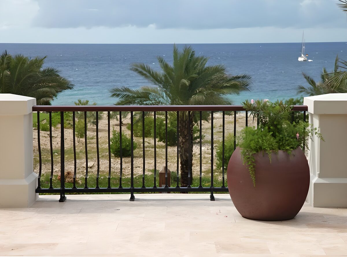 WCUK48005: Flowerpot with plant with a view over the Caribbean and catmaran